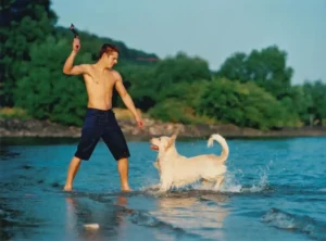 IVH - Junger Mann mit Hund am Strand